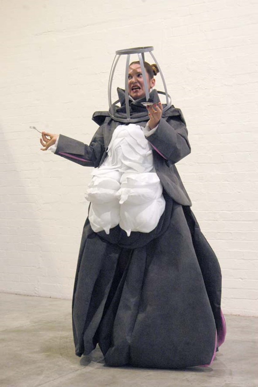 Hanna Hoyne & Anna Simic: Grey (A Cage Opera Series) (2005-2007). Anna Simic shown in performance as character GREY at Dianne Tanzer Gallery in Melbourne.  The series comprised four characters Grey /White/Pink/ Gold were co-developed and installed each in a sculptural installation that Simic performed within. Photo: Carla Gottgens.